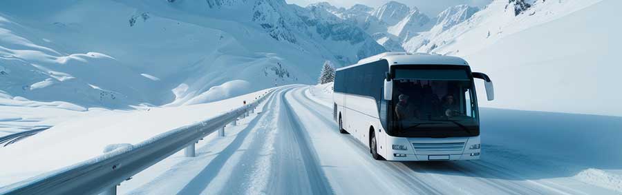 Luxury motor coach on a road covered in snow in the beautiful mountains