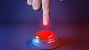 Finger poised over a glowing red panic button—symbolizing the urgent, high-stakes decisions nonprofits face in uncertain times.
