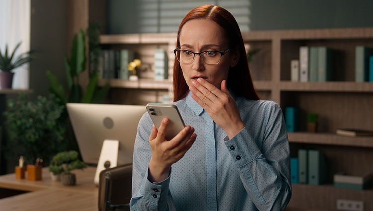 Financial advisor reading messages on smartphone disappointed at the news. Why should advisors embrace philanthropy? Because the Great Wealth Transfer is already happening.
