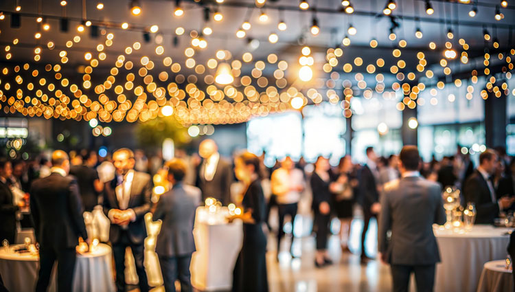 Guests mingle at an elegant nonprofit gala under warm string lights, embodying a spirit of connection and intentional hospitality. When nonprofit events lead with hospitality, we move from transactions to transformations; build relationships; and embrace missions.